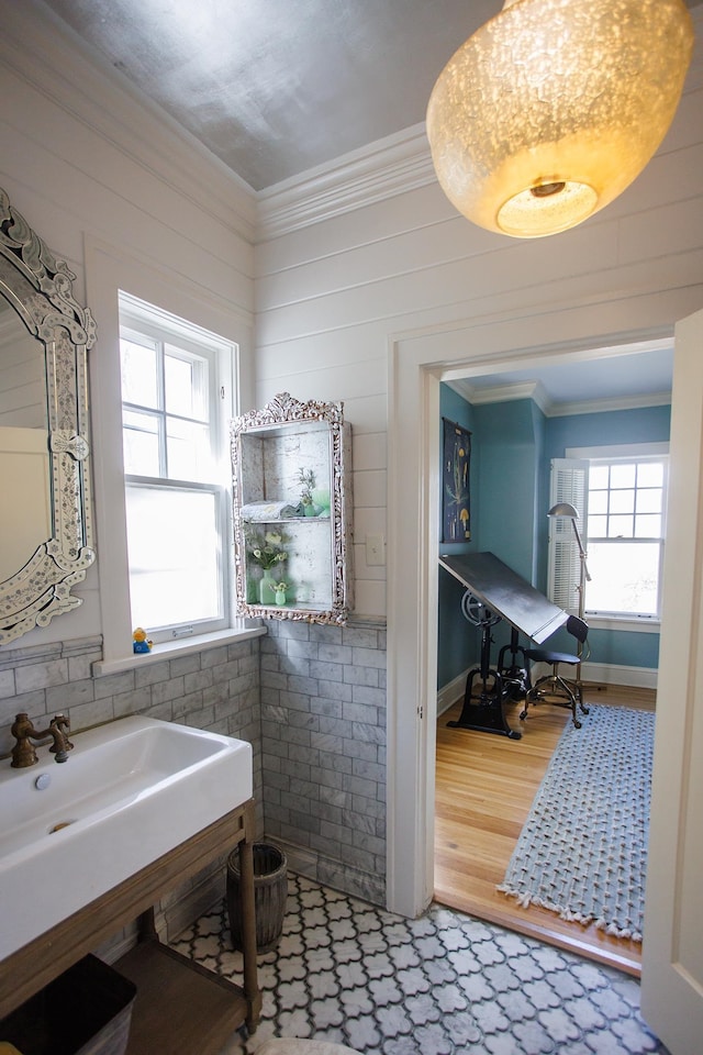 bathroom featuring a sink, crown molding, and wood finished floors