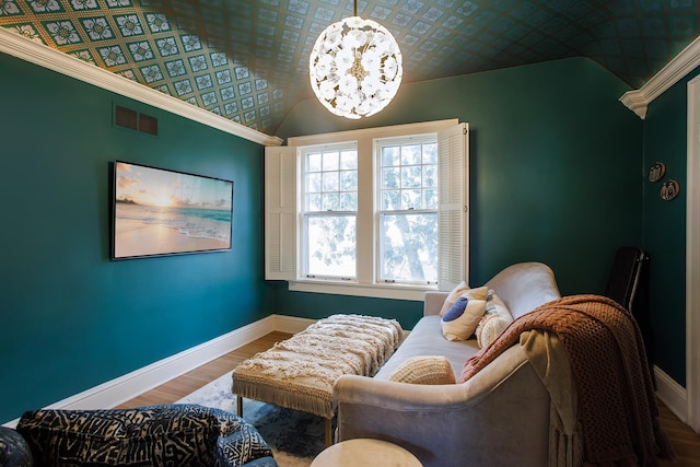 living area with an ornate ceiling, baseboards, a chandelier, visible vents, and wood finished floors