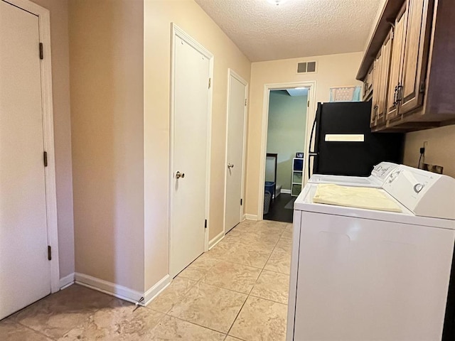 1653 Brierbrook Rd, Germantown, TN 38138 - clothes washing area featuring cabinet space, separate washer and dryer, a textured ceiling, light tile patterned flooring, and baseboards