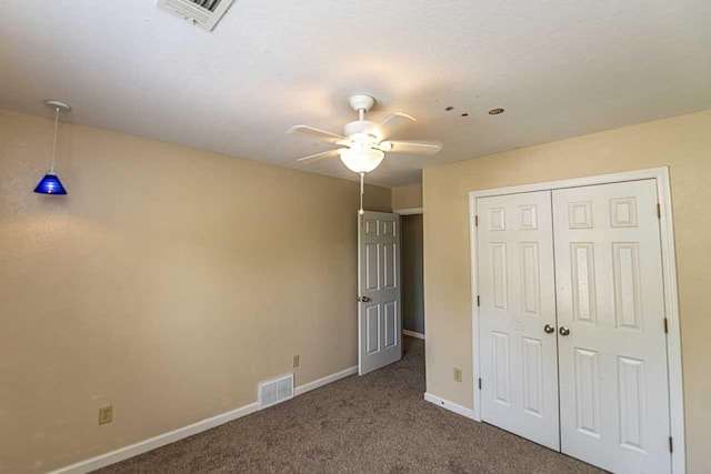 unfurnished bedroom with a closet, visible vents, carpet flooring, and baseboards