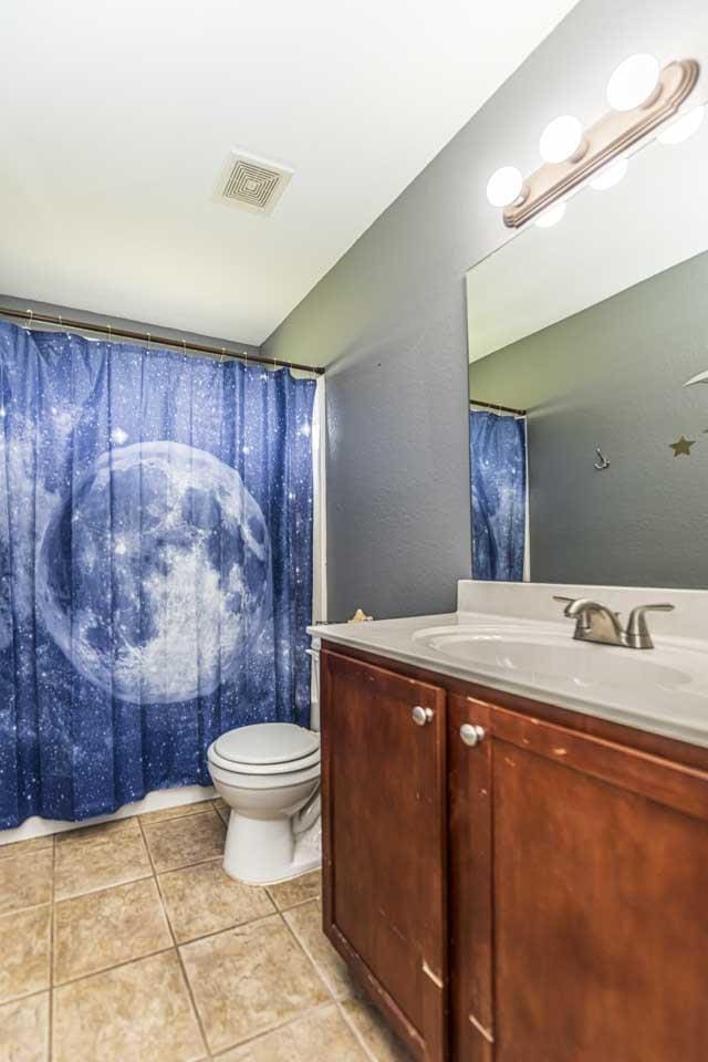 full bathroom with tile patterned floors, visible vents, vanity, and toilet