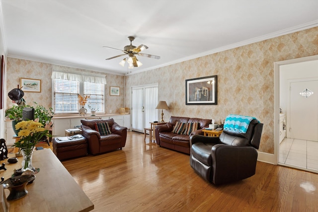 living room with ornamental molding, wood finished floors, ceiling fan, and wallpapered walls