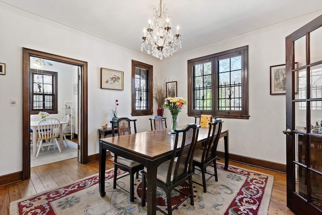 dining area featuring a healthy amount of sunlight, ornamental molding, and an inviting chandelier
