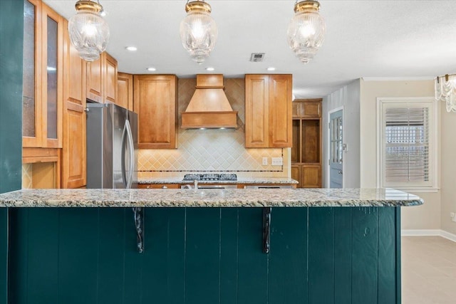 2060 Abergeldie Dr, Memphis, TN 38119 - kitchen with visible vents, custom exhaust hood, light stone countertops, backsplash, and freestanding refrigerator