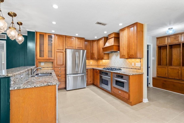 2060 Abergeldie Dr, Memphis, TN 38119 - kitchen with a sink, light stone counters, appliances with stainless steel finishes, custom exhaust hood, and brown cabinets