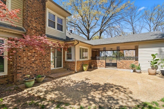 2060 Abergeldie Dr, Memphis, TN 38119 - view of exterior entry featuring a patio, brick siding, and roof with shingles