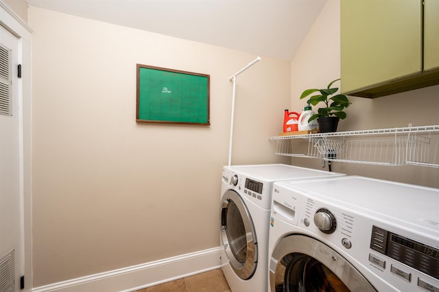 clothes washing area with tile patterned flooring, washer and clothes dryer, and baseboards