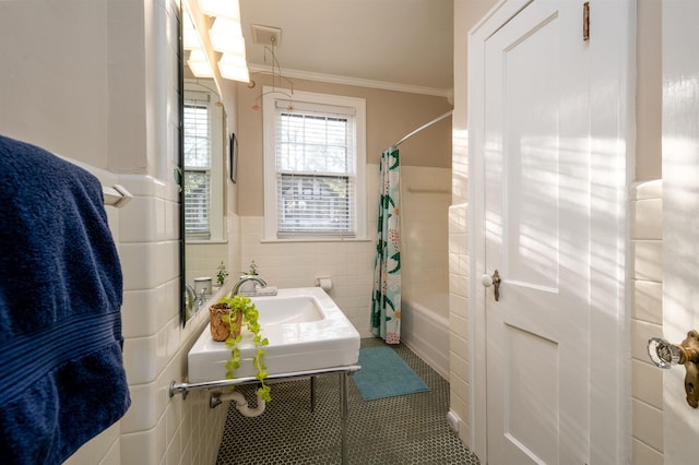 bathroom featuring tile walls, a wainscoted wall, ornamental molding, tile patterned floors, and shower / bathtub combination with curtain