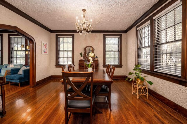 dining room featuring ornamental molding, a textured wall, and an inviting chandelier
