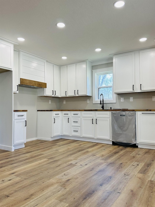 kitchen featuring light wood finished floors, recessed lighting, white cabinets, and dishwasher