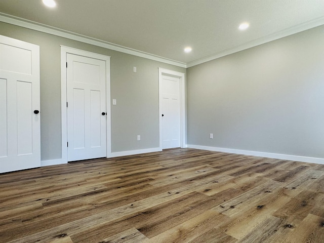 interior space featuring baseboards, wood finished floors, and ornamental molding