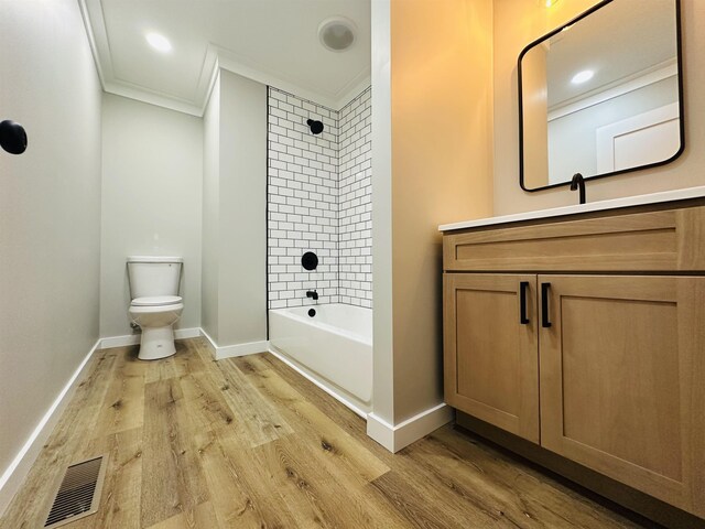 bathroom featuring visible vents, toilet, crown molding, and wood finished floors