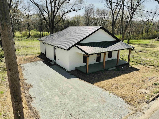 exterior space with metal roof, stucco siding, and a porch