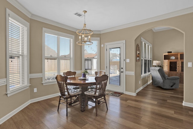 dining space with visible vents, a chandelier, baseboards, wood finished floors, and arched walkways