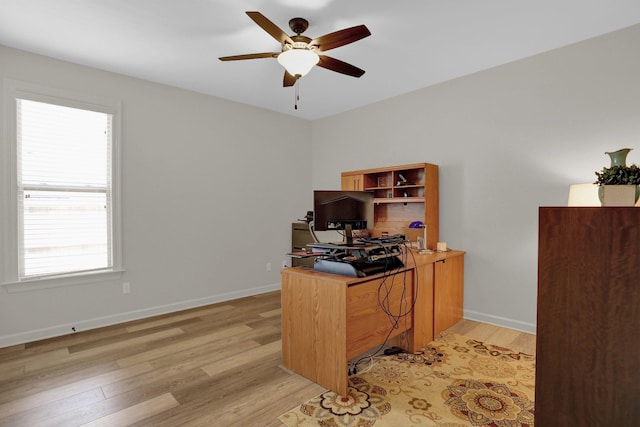 office featuring baseboards, light wood-style flooring, and a ceiling fan