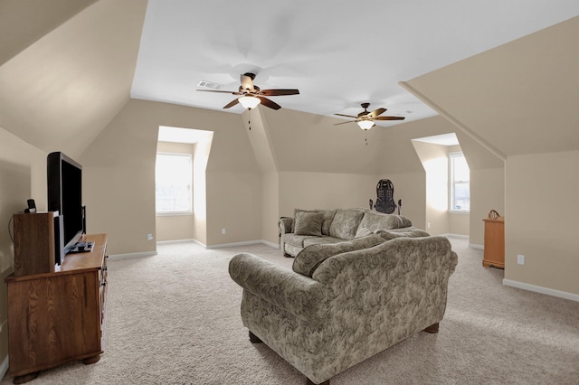 living area with baseboards, ceiling fan, visible vents, and light colored carpet