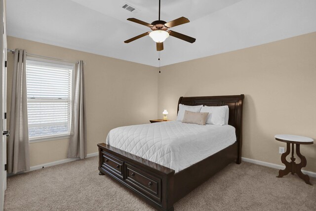 bedroom with baseboards, ceiling fan, visible vents, and light carpet
