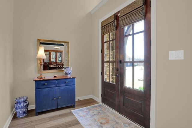 foyer entrance featuring plenty of natural light, baseboards, light wood-style floors, and french doors