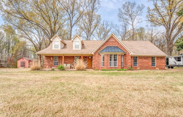 view of front of house with covered porch, a front yard, and a shingled roof