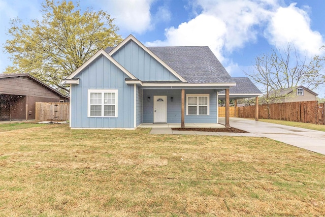 view of front of property featuring fence, concrete driveway, an attached carport, a front lawn, and board and batten siding