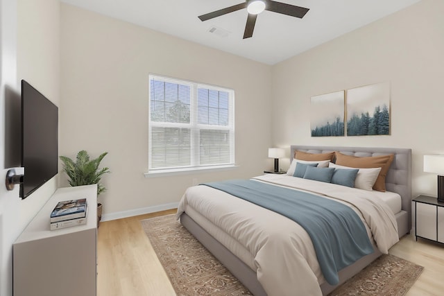bedroom featuring baseboards, visible vents, light wood-style floors, and a ceiling fan