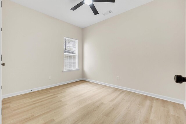 empty room featuring baseboards, visible vents, ceiling fan, and light wood-style flooring