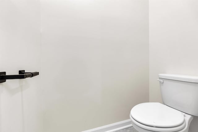 bathroom with toilet and baseboards