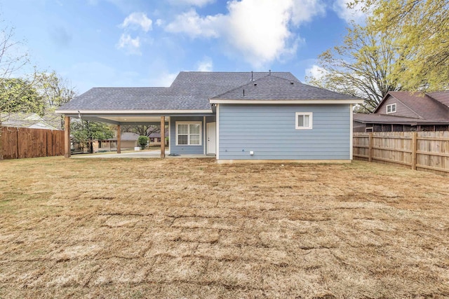 back of property featuring a patio, a shingled roof, a lawn, and a fenced backyard