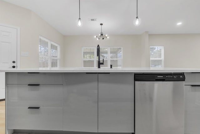 kitchen featuring light countertops, a chandelier, stainless steel dishwasher, a sink, and visible vents