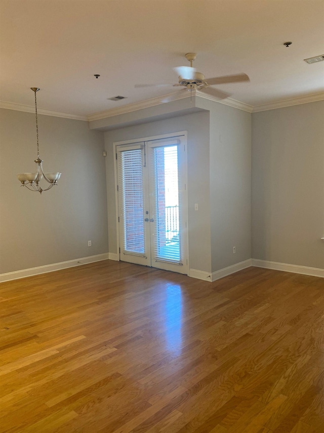 empty room with light wood finished floors, french doors, visible vents, and crown molding