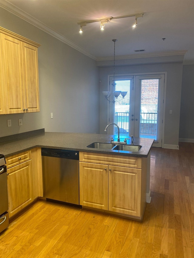 kitchen with dark countertops, light wood finished floors, stainless steel dishwasher, and a sink