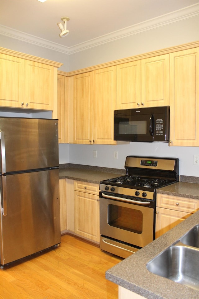 kitchen with light wood finished floors, stainless steel appliances, a sink, light brown cabinets, and ornamental molding