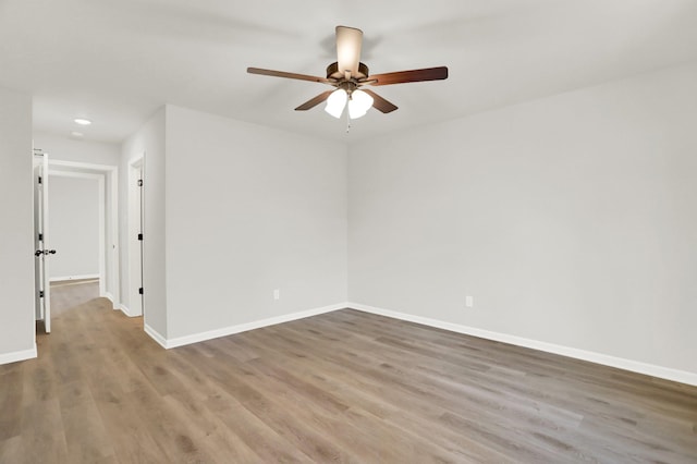 spare room featuring a ceiling fan, recessed lighting, baseboards, and wood finished floors