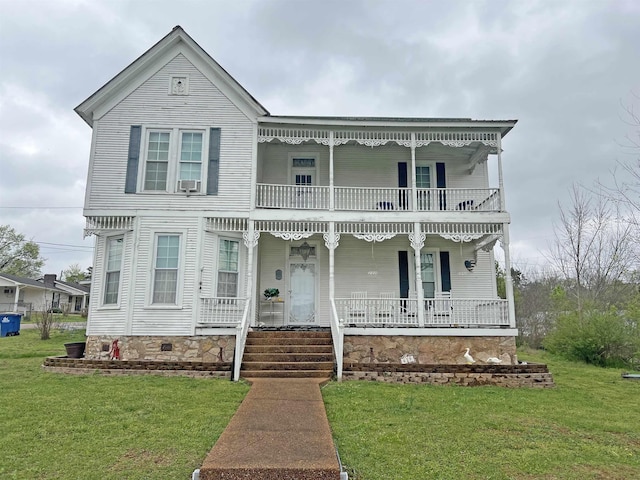 view of front of property featuring a front yard, a balcony, a porch, and cooling unit