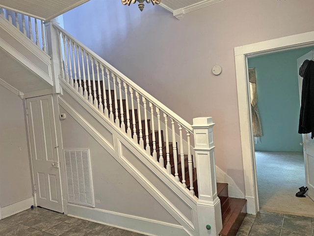 stairs featuring baseboards, a high ceiling, visible vents, and carpet