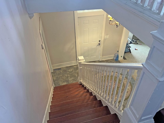 stairs with visible vents and wood finished floors