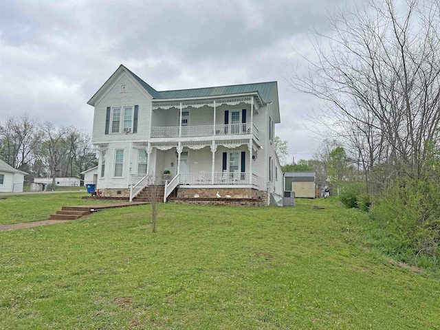 view of front of house featuring covered porch, a balcony, a front lawn, metal roof, and crawl space