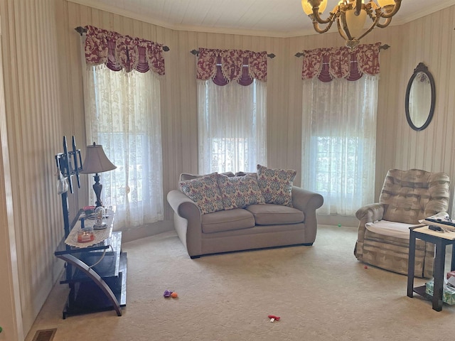 carpeted living area featuring crown molding, wooden walls, a chandelier, and visible vents