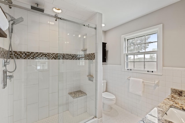 90 Grove Dale St, Memphis, TN 38120 - bathroom featuring a shower stall, toilet, wainscoting, tile walls, and vanity