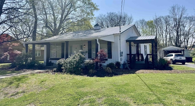 417 E Tigrett St, Halls, TN 38040 - view of property exterior featuring a lawn, metal roof, and a porch