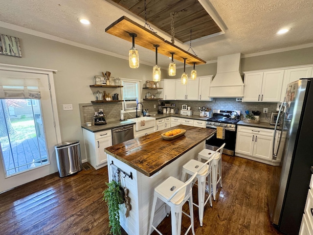 417 E Tigrett St, Halls, TN 38040 - kitchen with open shelves, premium range hood, stainless steel appliances, dark wood-type flooring, and butcher block counters