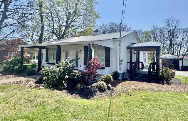 417 E Tigrett St, Halls, TN 38040 - view of front facade featuring a porch, metal roof, and a front lawn