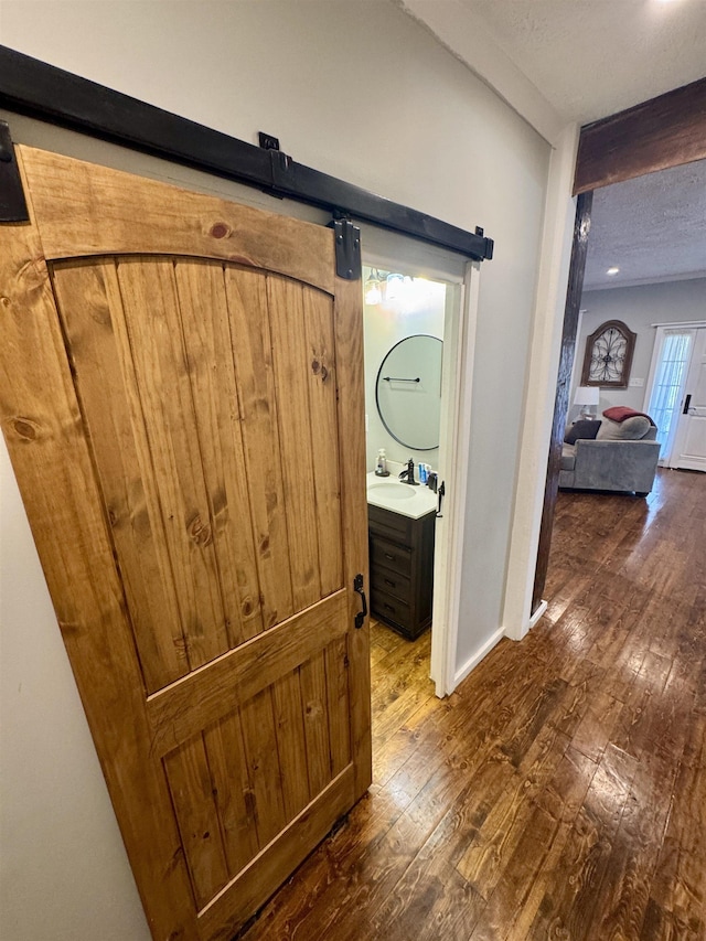 417 E Tigrett St, Halls, TN 38040 - corridor featuring a sink, hardwood / wood-style flooring, a barn door, and a textured ceiling