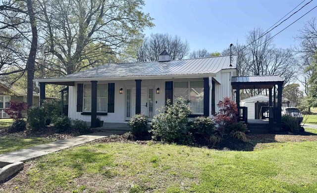417 E Tigrett St, Halls, TN 38040 - view of front facade with metal roof, a front lawn, board and batten siding, and a porch