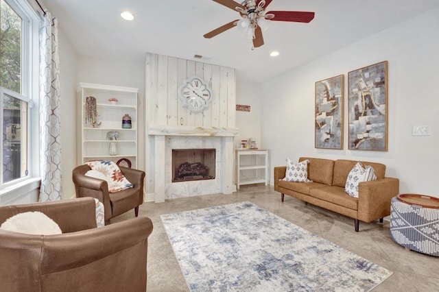 living room with visible vents, a premium fireplace, recessed lighting, and a ceiling fan