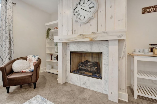 living area with baseboards, a fireplace, and tile patterned flooring