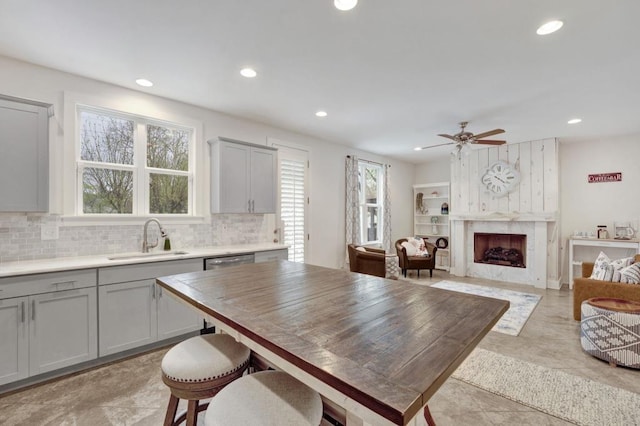 kitchen with a ceiling fan, a sink, gray cabinetry, and decorative backsplash