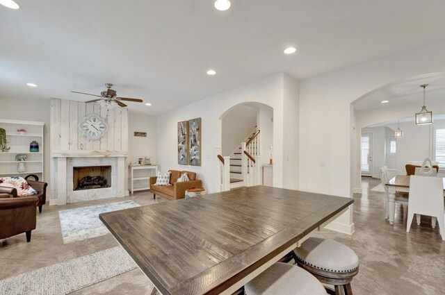 dining space with arched walkways, stairs, ceiling fan, and recessed lighting