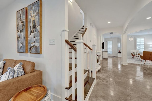 stairs featuring arched walkways, baseboards, and recessed lighting
