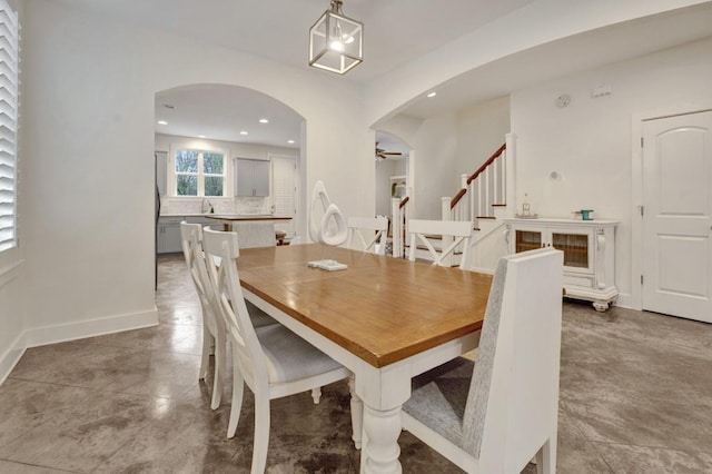 dining area featuring stairway, recessed lighting, baseboards, arched walkways, and a ceiling fan